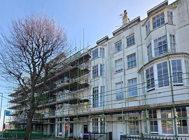 An image of AO Hostel, a 5 storey building with scaffolding around it.